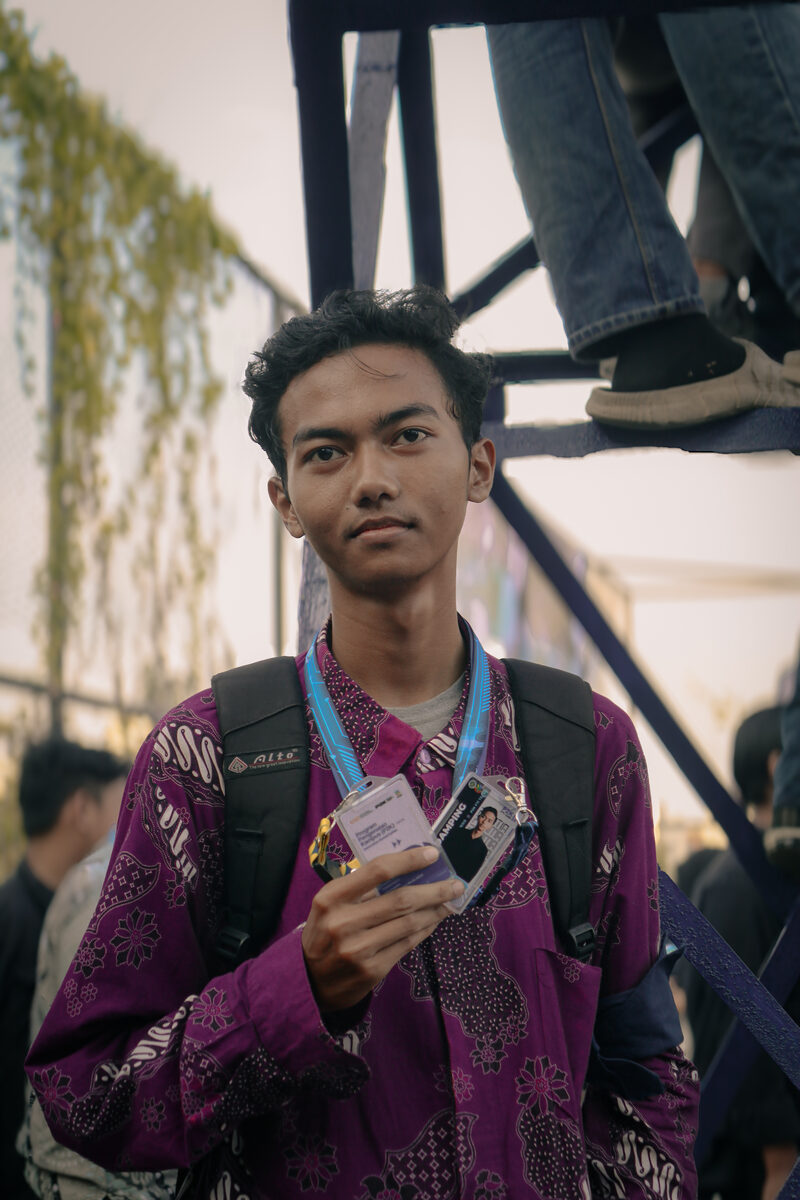 Portrait of Itoshiko Nurahman holding an event ID card